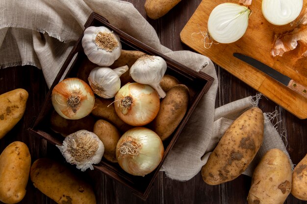 Bovenaanzicht van knoflook met uien en aardappelen