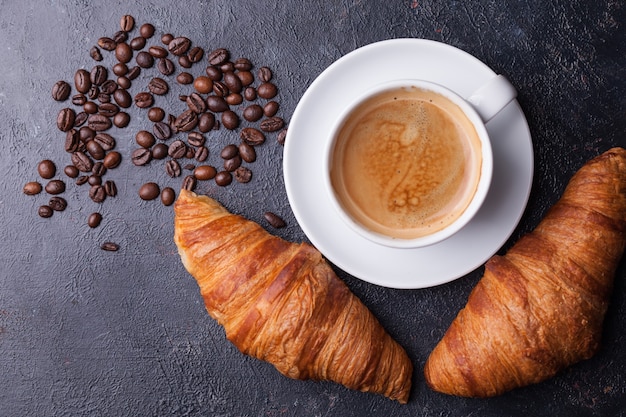 Bovenaanzicht van koffie en croissant met koffiebonen. heerlijke koffie.
