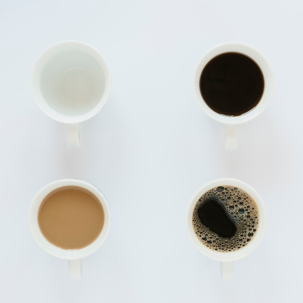 Bovenaanzicht van koffie kopjes op witte tafel