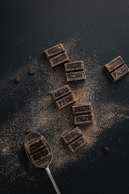 Bovenaanzicht van koffiebonen en donkere chocoladestukjes bestrooid met cacaopoeder