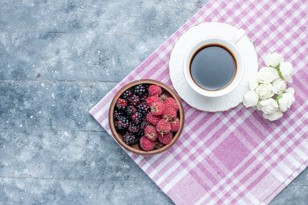 bovenaanzicht van kom met bessen vers en rijp fruit met koffie op grijs, bessen fruit vers rijp zacht bos