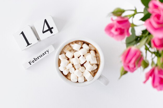 Bovenaanzicht van kopje marshmallows met rozen en datum