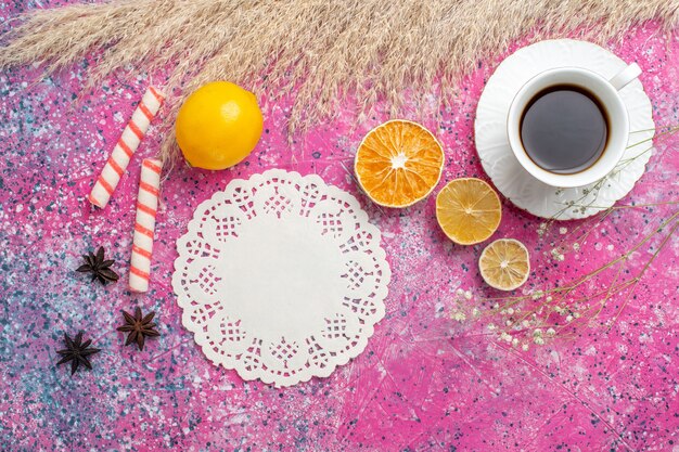 Bovenaanzicht van kopje thee met citroen op roze oppervlak