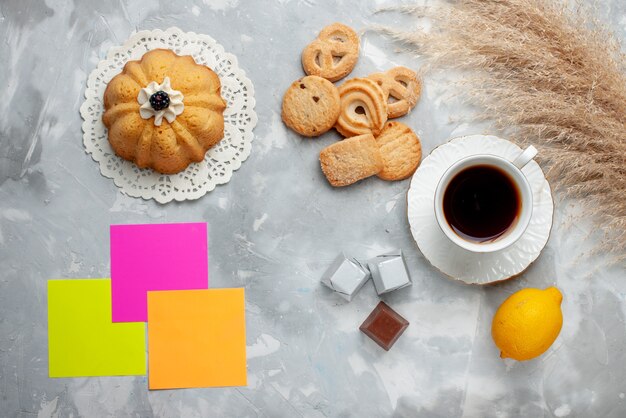 Bovenaanzicht van kopje thee warm met chocolade citroen kleine cake en koekjes op licht, koekje snoep chocolade thee koekje zoet