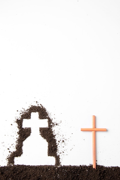 Gratis foto bovenaanzicht van kruisvorm met donkere grond op witte muur