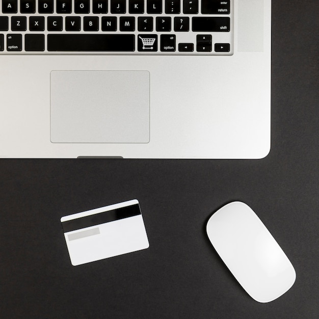 Bovenaanzicht van laptop met muis en creditcard