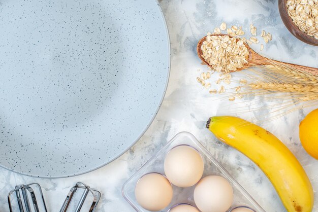 Bovenaanzicht van lege grijze plaat en ingrediënten voor de gezonde voeding op ijstafel