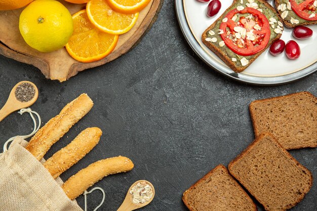 Bovenaanzicht van lekkere avocado sandwiches met sinaasappels op grijze ondergrond