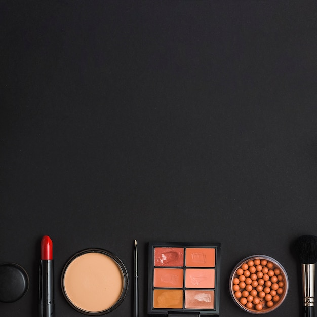 Gratis foto bovenaanzicht van make-up producten aan de onderkant van zwarte achtergrond