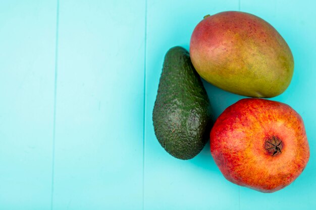 Bovenaanzicht van mango met avocado granaatappel op blauwe ondergrond