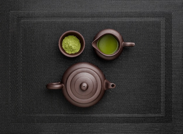 Bovenaanzicht van matcha-thee in theepot en poeder