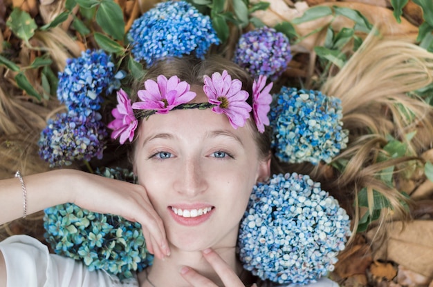 Bovenaanzicht van mooie meisje omgeven door bloemen
