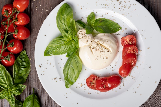 Bovenaanzicht van mozzarella en cherry tomaten op houten tafel