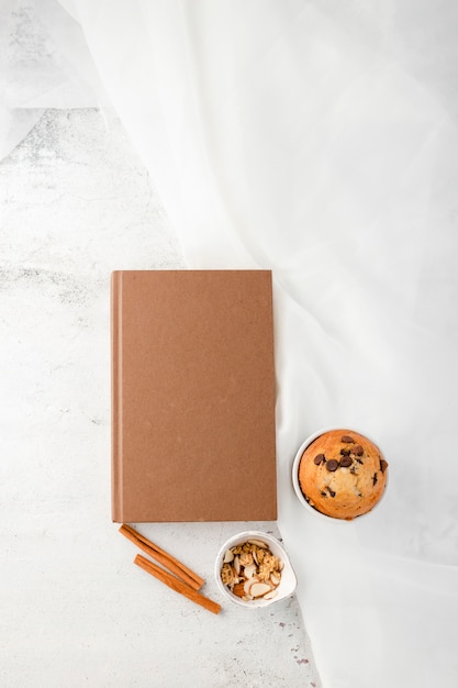 Bovenaanzicht van muffin naast granen en notebook