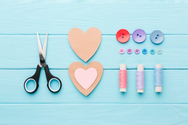 Bovenaanzicht van naaibenodigdheden met Valentijnsdag papier harten