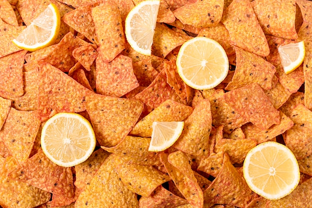 Gratis foto bovenaanzicht van nacho chips met plakjes citroen