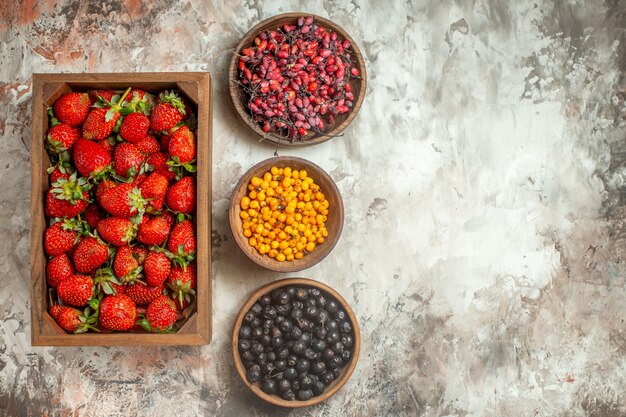 Bovenaanzicht van natuurlijk vers fruit in een houten kist en kleine bruine potten