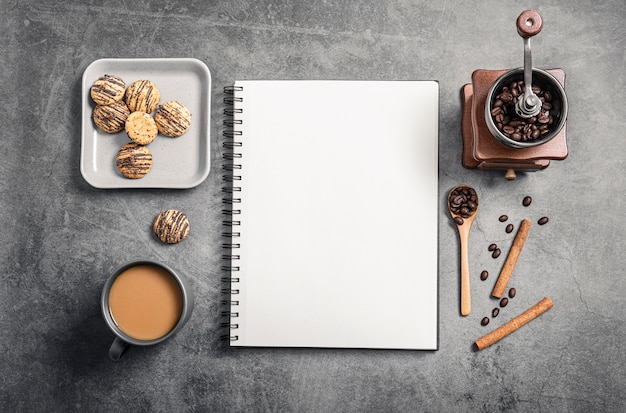 Bovenaanzicht van notebook met koffiekopje en grinder