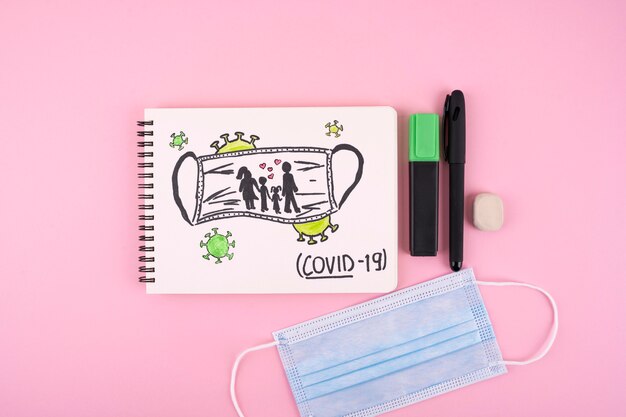 Bovenaanzicht van notebook met medisch masker en pen