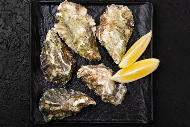 Gratis foto bovenaanzicht van oesters met plakjes citroen