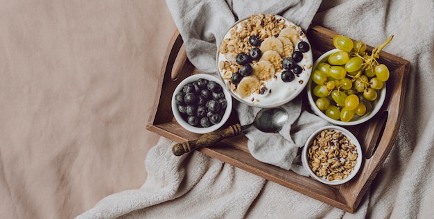 Bovenaanzicht van ontbijt op bed met granen en druiven