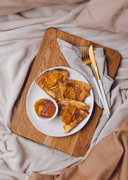 Bovenaanzicht van ontbijt pannenkoeken in bed met jam