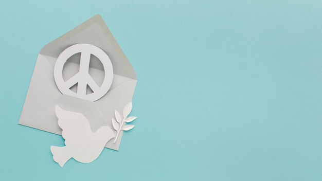 Bovenaanzicht van papier duif met envelop en vredesteken