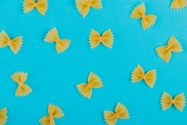 Bovenaanzicht van patroon van farfalle pasta op blauwe ondergrond