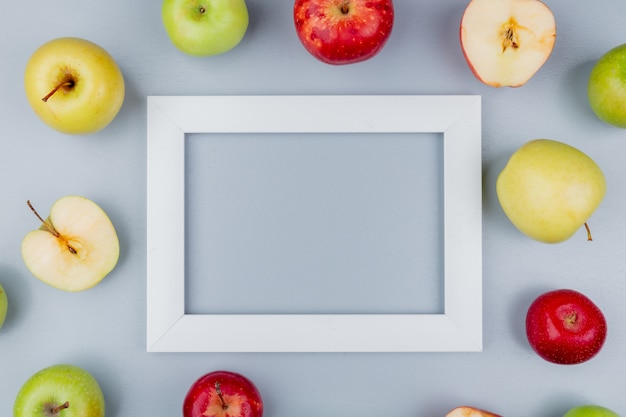 Bovenaanzicht van patroon van knippen en hele appels rond frame op grijze achtergrond met kopie ruimte