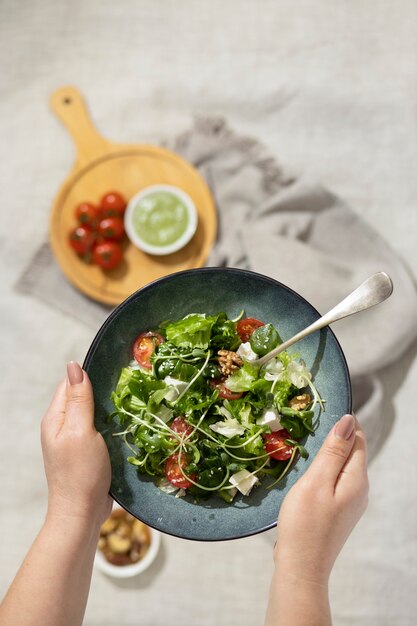 Bovenaanzicht van persoon met een bord salade en een vork