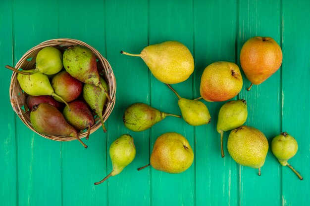 Bovenaanzicht van perziken in mand op groene ondergrond