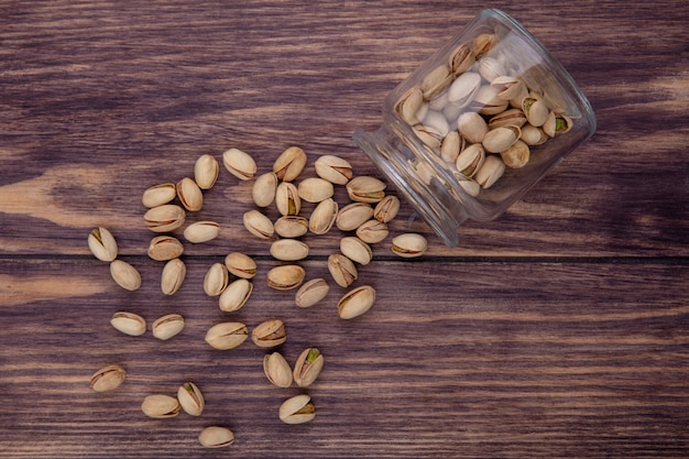 Bovenaanzicht van pistachenoten in een pot op een houten oppervlak