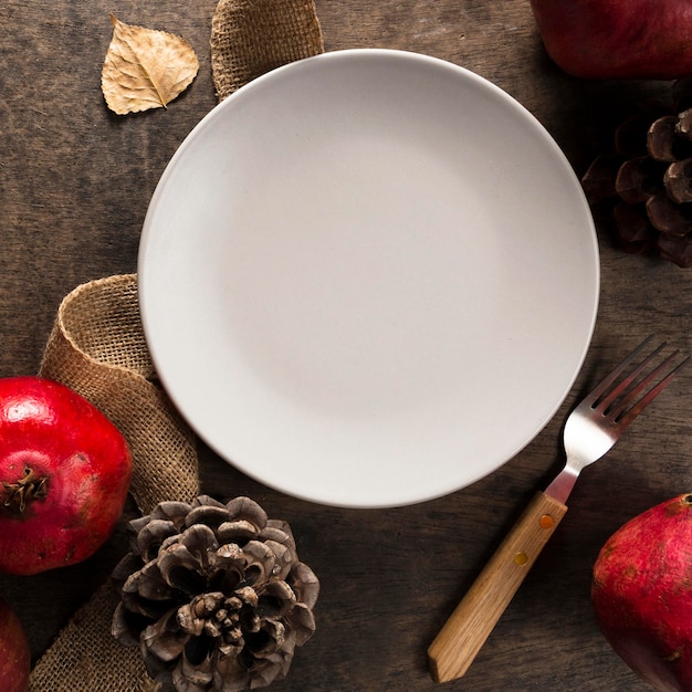 Bovenaanzicht van plaat met herfst granaatappel en dennenappels