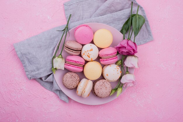 Bovenaanzicht van plaat met macarons en rozen