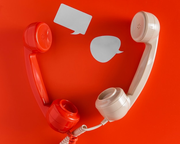 Bovenaanzicht van praatjebellen met twee telefoonontvangers en snoer
