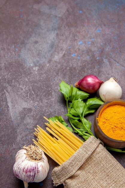 Bovenaanzicht van rauwe pasta met knoflook op zwart