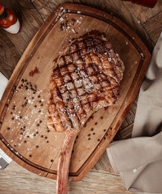 Bovenaanzicht van ribeye steak geserveerd op een houten bord
