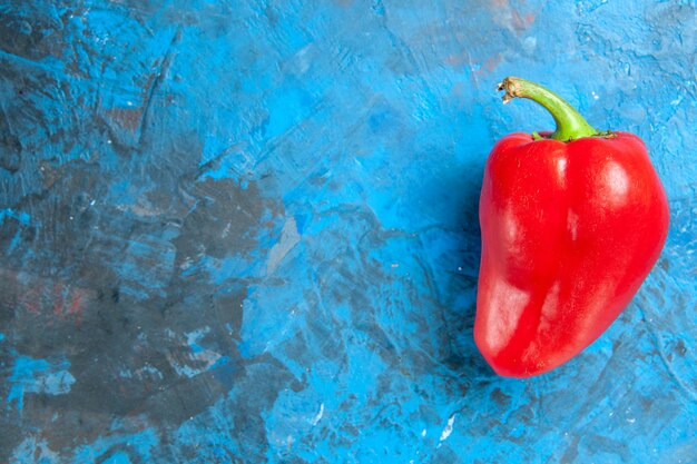 Bovenaanzicht van rode paprika op blauwe ondergrond