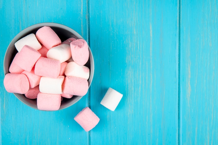 Gratis Foto bovenaanzicht van roze en witte marshmallow in een kom op blauw