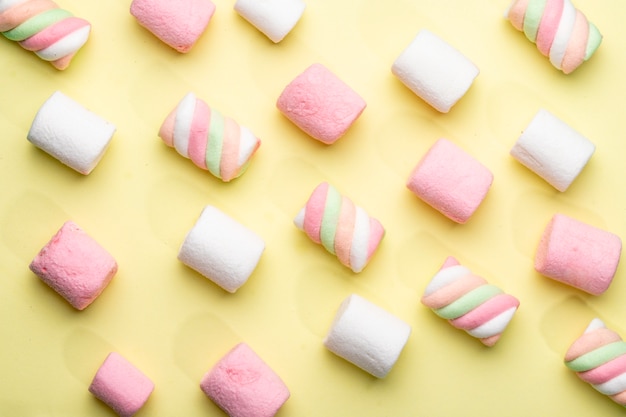 Bovenaanzicht van roze en witte marshmallow op geel