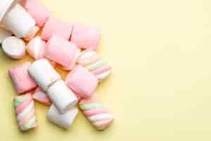 Gratis foto bovenaanzicht van roze en witte marshmallow verspreid op geel