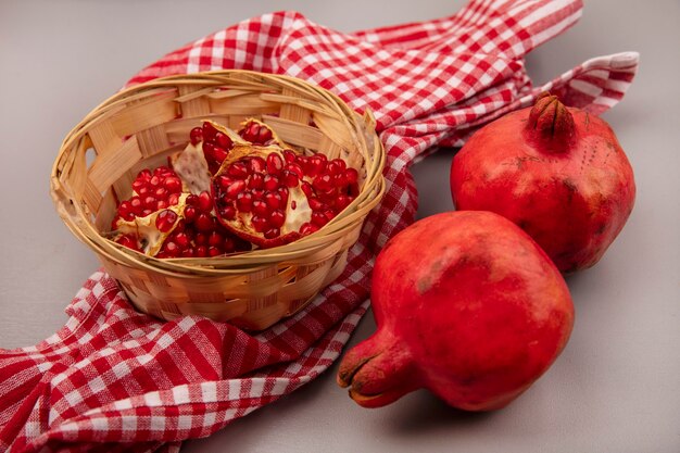 Bovenaanzicht van sappige en gezonde granaatappels op een emmer op een gecontroleerde doek