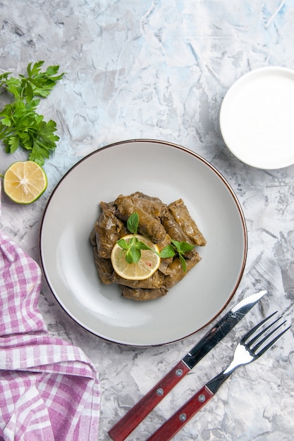 Bovenaanzicht van smakelijke blad dolma binnen plaat op wit oppervlak