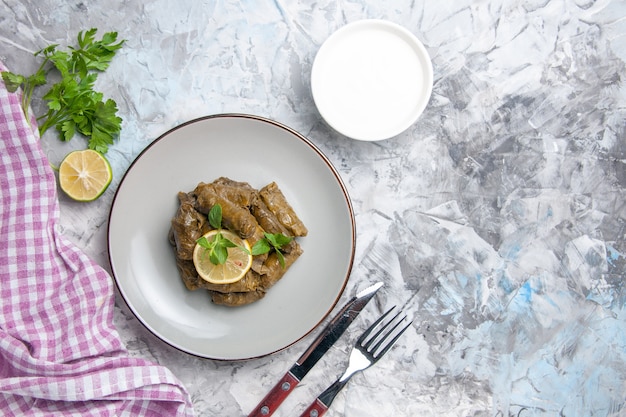 Bovenaanzicht van smakelijke blad dolma binnen plaat op wit oppervlak