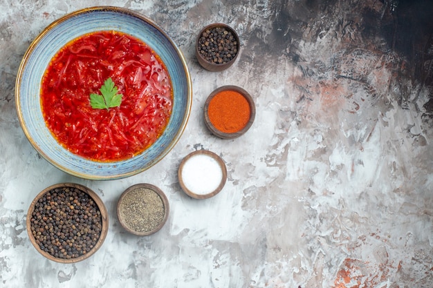 Bovenaanzicht van smakelijke borsch Oekraïense bietensoep met kruiden op witte ondergrond