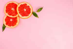 Gratis foto bovenaanzicht van smakelijke grapefruits op roze oppervlak