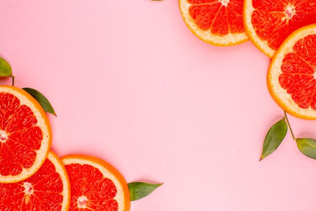 Bovenaanzicht van smakelijke grapefruits op roze oppervlak