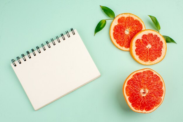 Bovenaanzicht van smakelijke grapefruits, sappig gesneden op het lichtblauwe oppervlak