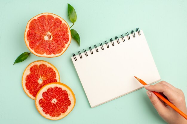 Bovenaanzicht van smakelijke grapefruits, sappig gesneden op het lichtblauwe oppervlak