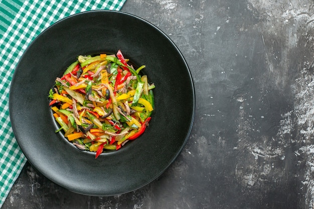 Bovenaanzicht van smakelijke groentesalade op donkere ondergrond